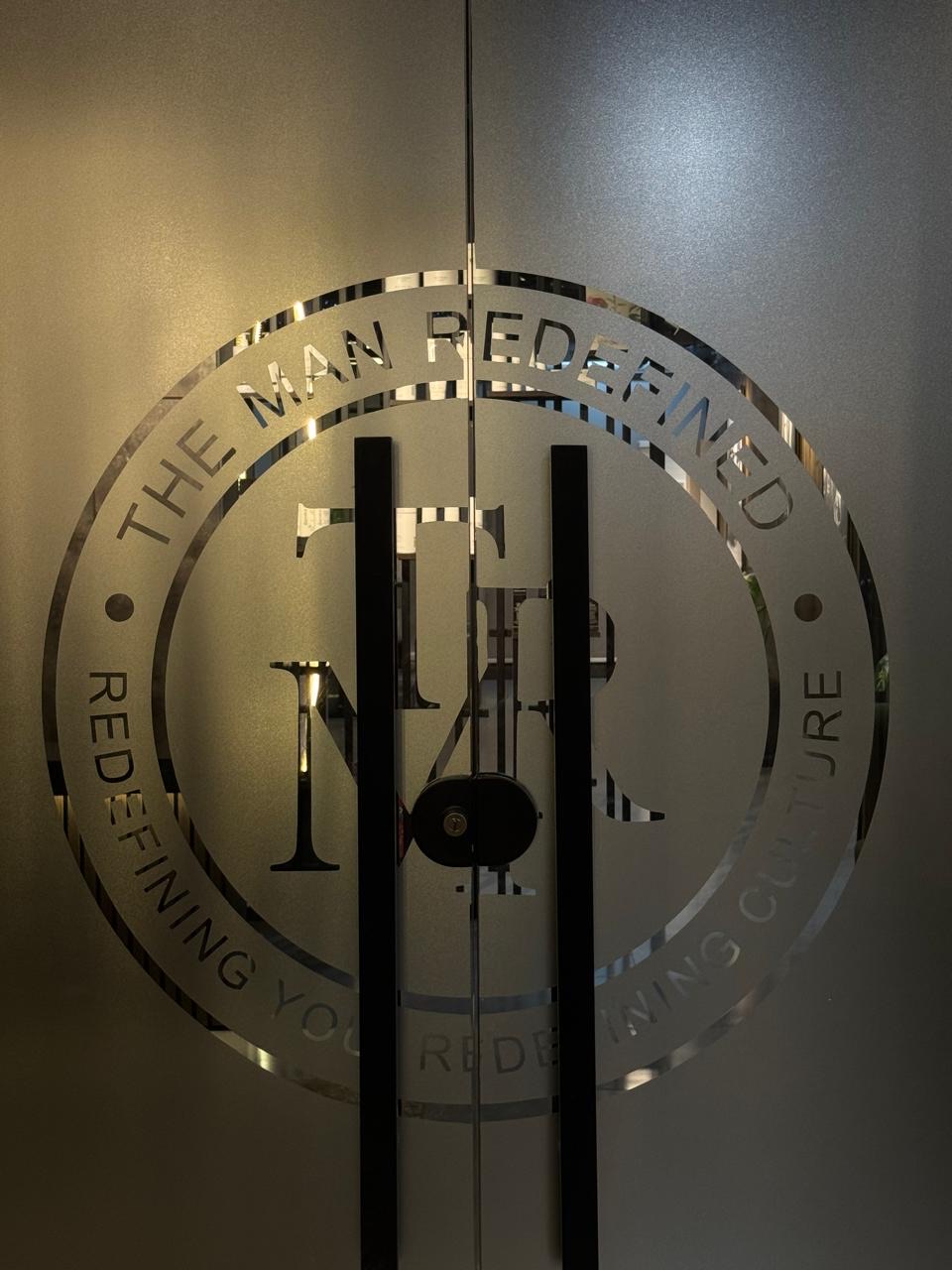 TMR logo etched on the frosted glass door of The Man Redefined